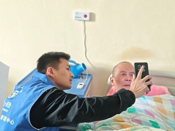 社保工作人员在养老院用手机帮助老人做资格认证（拍摄者：孙欣欣）.jpg