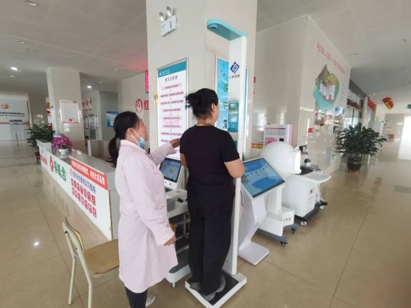 图为十二团医院导医为患者进行免费体重检测，向患者普及体重管理知识。.jpg