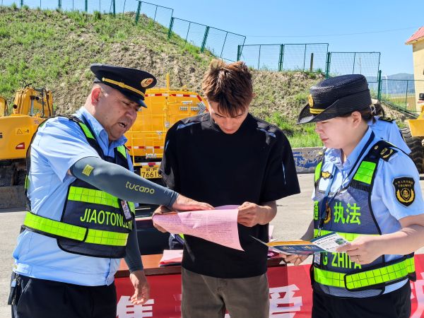 图1：执法人员向过往司乘人员发放宣传资料.jpg