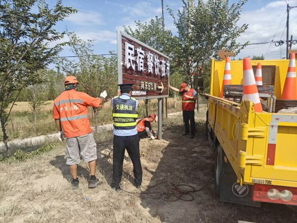 图片1：执法人员联合养护人员对公路控制区内摆放的广告牌进行清理.jpg