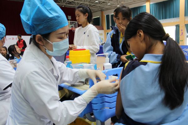 9月15日，图为十二团医院公卫科计划免疫专干在十二团中学体验馆为学生接种麻腮风疫苗。.JPG