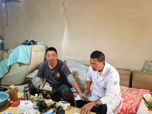 在第28个全国高血压日期间，十二团医院基层连队卫生员上门为居民测血压及健康指导服务。.jpg
