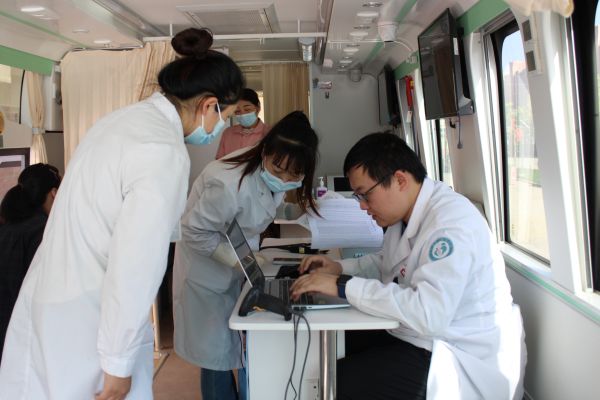 图为十二团医院公卫科计划免疫工作人员核对接种流感疫苗老人信息。.JPG