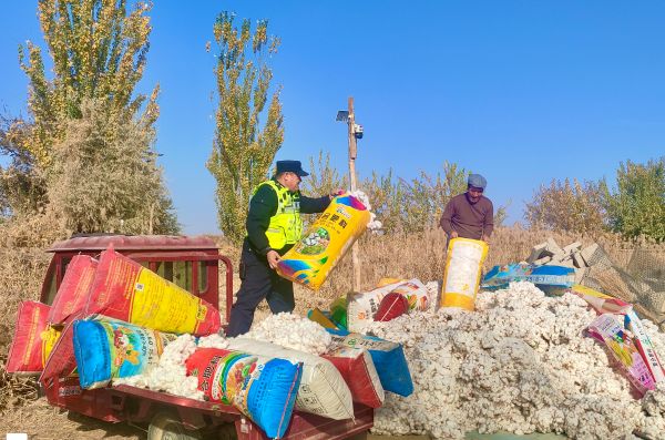 民警从车辆上搬运新棉絮，老人在一旁帮助整理.jpg