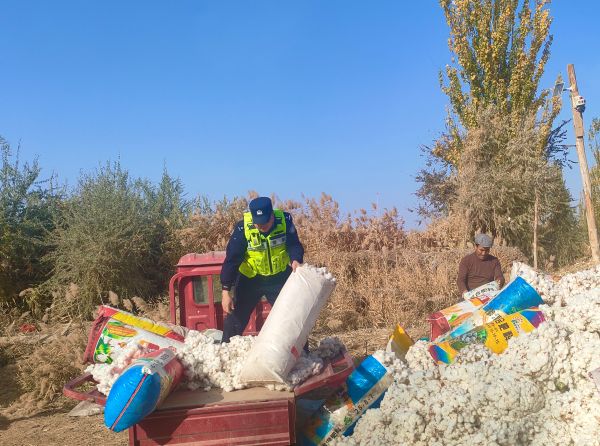 民警从车辆上搬运新棉絮的场景.jpg