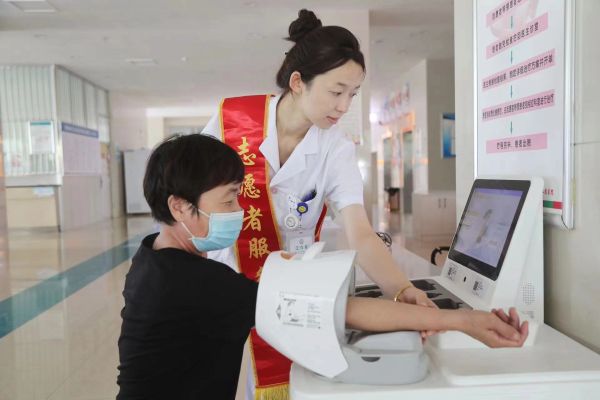 9月9日，图为十二团医院志愿者在“智慧健康小屋”为来院就诊患者免费测量血压。.jpg