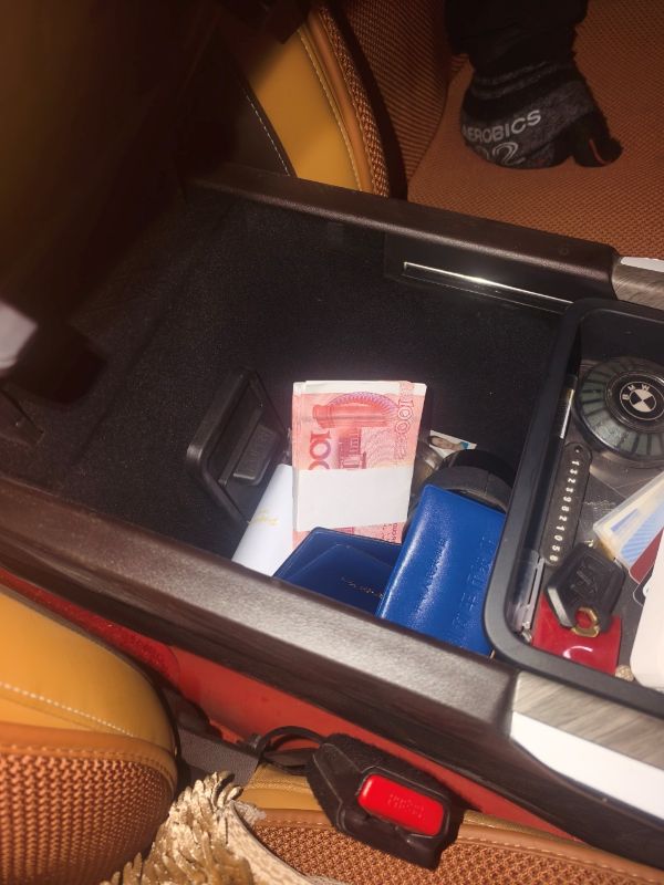 12081765189507277468.jpg 车内扶手箱里,1万元现金与证件等物品随意放置。敬浩龙摄.jpg
