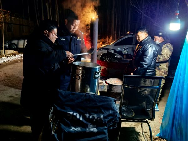 慰问组与执勤人员围在冒着热气的保温桶旁。黄雯璐摄.jpg