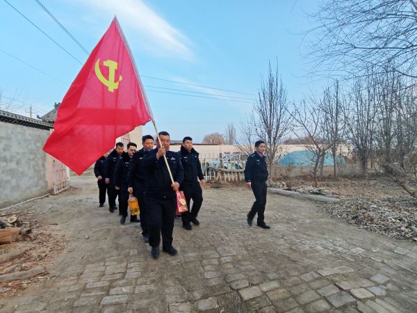党员团员民辅警们高举党旗，手拎慰问品，迈着坚定的步伐走在乡间小路上，前往孤寡老人家中开展慰问活动。黄雯璐摄.jpg