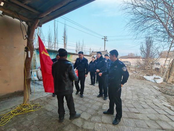 在老人家门口，民辅警们与老人亲切会面，鲜红的党旗在一旁迎风飘扬，定格下党团关怀的温暖瞬间。敬浩龙摄.jpg