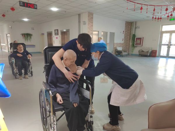 图为十二团医院公卫科医务人员上门为养老院行动不便的老人接种流感疫苗。.jpg