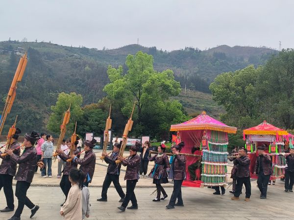 图为 在贵州省从江县北上鼓楼广场，侗族同胞吹奏芦笙，用轿子抬退役军人游行（鲁畅 摄）.jpg