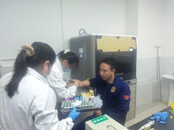 图为消防员积极配合医务人员进行采血.jpg