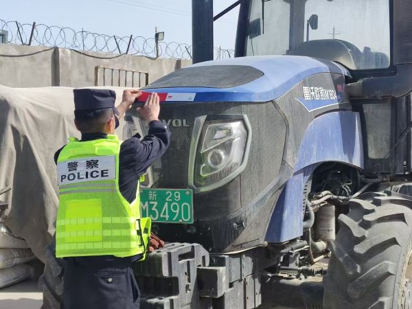 警务人员给偏远散户的农用机器贴反光贴.jpg