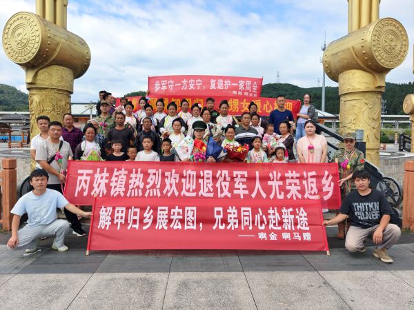 09021788343203456418.jpg 图为 丙妹镇“接亲团”在高铁站迎接退役军人合影现场(杨盛 摄).jpg