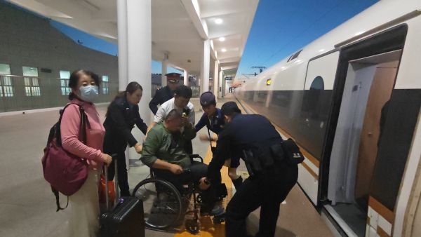 10091791540856179105.jpg 乘警与列车工作人员一同将患病旅客送下火车.jpg